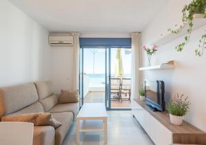 a living room with a couch and a tv at Apartamentos Varadero Sea View in Cala del Moral