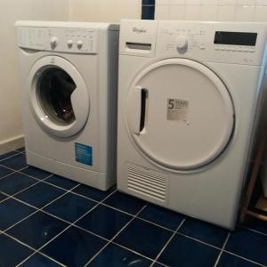 een wasmachine en een droger op een tegelvloer bij La Giara in La Spezia