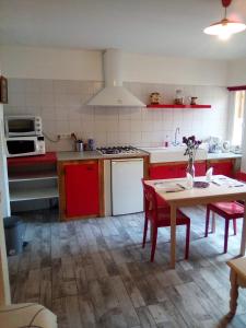 a kitchen with red and white appliances and a table at Charmant studio centre ville Mirepoix in Mirepoix