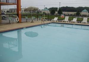 uma grande piscina com cadeiras e mesas e cadeiras em Econo Lodge Inn and Suites - Jackson em Jackson