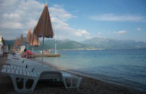 - une plage avec des chaises et des parasols au bord de l'eau dans l'établissement Adriadome Paradise Bijela, à Bijela