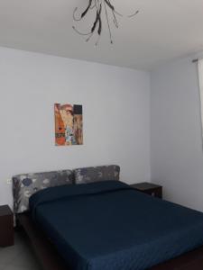 una camera con un letto e una coperta blu di Appartamento Il Golfo dei Poeti e 5 Terre a 2 passi a La Spezia