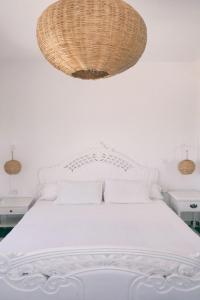 Un dormitorio con una cama blanca con una gran lámpara de araña en Blue Kaouki, en Sidi Kaouki