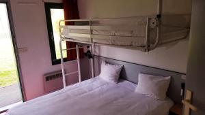 een bed in een kamer met een stapelbed en een raam bij Premiere Classe Périgueux - Boulazac in Boulazac