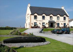 a large white building with cars parked in front of it at Pier House Bed & Breakfast in Inis Mor