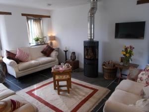uma sala de estar com um fogão a lenha em The Barn At Collacott em North Petherwin