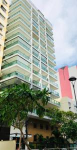 a tall building with a tree in front of it at loft london, conforto no coração de Icarai in Niterói