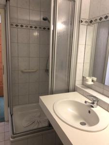 a bathroom with a sink and a shower at Norishütte in Mittelberg