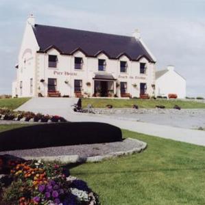 a large white building with a black roof at Pier House Bed & Breakfast in Inis Mor