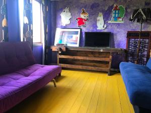a living room with a purple couch and a tv at Station Villa Vimmerby in Vimmerby