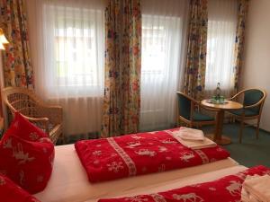 a bedroom with a bed and a table and window at Norishütte in Mittelberg