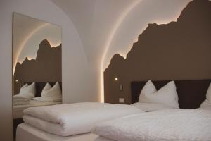 1 dormitorio con 2 camas y almohadas blancas en DolceVita Ambiez B&B en San Lorenzo in Banale