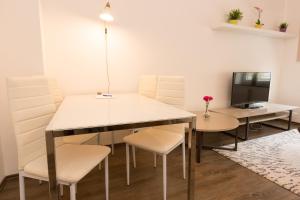 ein Esszimmer mit einem Tisch und Stühlen sowie einem TV in der Unterkunft T3 Cityloft Appartments in Mönchengladbach