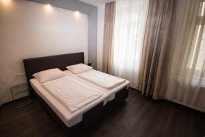 a bed with white sheets and pillows in a bedroom at Hotel Luisenhof Wiesbaden - Innenstadt und RMCC in Wiesbaden +4 photos