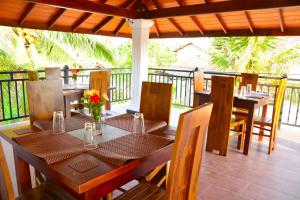 a dining room with a table and chairs on a porch at Brisa Marina in Negombo