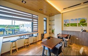 a restaurant with tables and chairs and a large window at 澎湖 翹家寶貝民宿 in Huxi