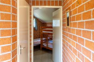 a brick walled room with a door leading to a bedroom at Kruisselbrink in Winterswijk