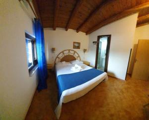 Un dormitorio con una cama con sábanas azules y una ventana. en Beb Eclissi, en Fontane Bianche