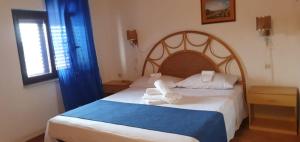 a bedroom with a bed with two towels on it at Beb Eclissi in Fontane Bianche