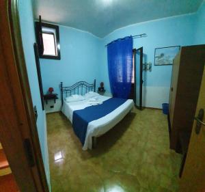 a bedroom with a bed in a blue room at Beb Eclissi in Fontane Bianche