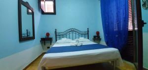 a blue bedroom with a bed with a teddy bear on it at Beb Eclissi in Fontane Bianche
