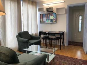 ein Wohnzimmer mit einem Sofa und einem Tisch mit Stühlen in der Unterkunft Apartments Ålholmvej in Kopenhagen