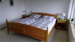 - un lit en bois avec deux oreillers dans une chambre dans l'établissement Ferienwohnung Asenberg, à Bad Salzuflen
