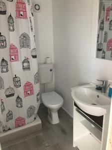 a bathroom with a toilet and a sink and a shower curtain at Estelle in Costinesti