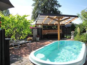 a hot tub in a backyard with a pergola at Agroturystyka Przylesie in Hajnówka