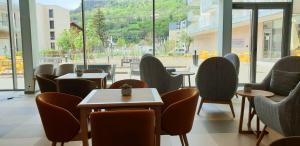 a restaurant with chairs and tables and windows at Domitys - Les Aiglons Blancs in Briançon