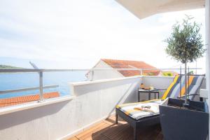 a balcony with a table and chairs and the ocean at Apartment Gallery in Primošten