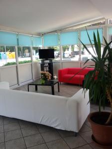 a living room with a white couch and a red couch at HOTEL OTELLO in Punta Marina +87 photos