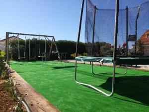 een speeltuin met groen gras en schommels bij Quinta Das Palmeiras in Quarteira