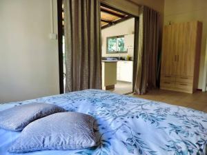 a bedroom with a blue bed with two pillows on it at Luxury Cosy Guesthouse in Pamplemousses Village