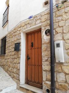 a wooden door on the side of a stone building at Casa Alba in Xert