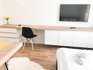 a living room with a desk and a black chair at Smart Home Žilina in Žilina
