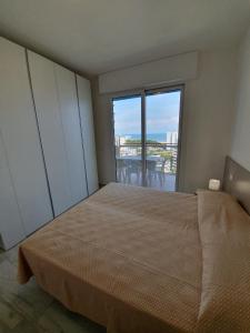 リニャーノ・サッビアドーロにあるResidence La Dunaのベッドルーム1室(ベッド1台、大きな窓付)