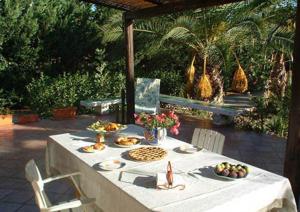 - une table avec des assiettes de nourriture sur une terrasse dans l'établissement Scopello Villa Sole, à Scopello