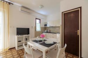a kitchen and dining room with a table and chairs at Apartmani Jordana in Komiža