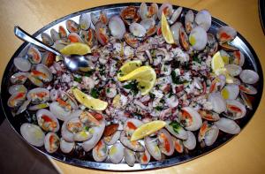 a plate of food with seafood and lemon slices at Hotel Villa Principe in San Nicola Arcella