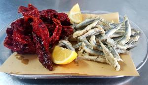 a plate of food with fish and a lemon at Hotel Villa Principe in San Nicola Arcella