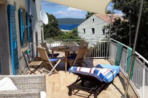 a patio with a table and chairs on a balcony at Ca' Flora in Nerezine