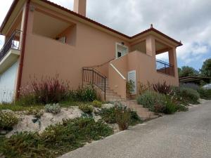 una casa con una escalera delante de ella en Sunny Coco mat villa in Katelios with a sea view, en Katelios