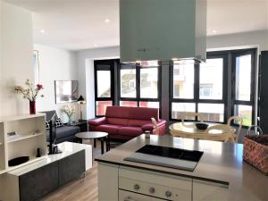 Una cocina y una sala de estar con un sofá rojo. en 4 Apartamentos de Autor, en Lugo