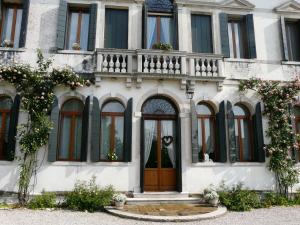 a white building with a wooden door and windows at Villa Caotorta in Ponzano Veneto