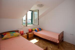 a room with two beds and a window at Yacht Beach Apartments in Kaštela