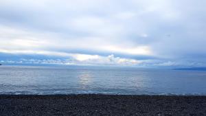 a beach with a cloudy sky and the ocean at Hotel Villa Principe in San Nicola Arcella