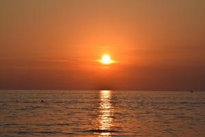 a sunset over the ocean with the sun in the sky at Hotel Villa Principe in San Nicola Arcella