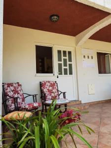 2 Stühle und ein Tisch auf einer Veranda in der Unterkunft Apartments Đule in Donji Morinj