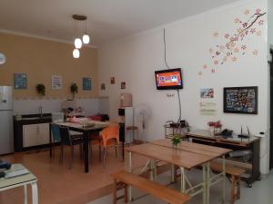 a dining room with tables and a tv on the wall at Ikiru to Live in Surabaya